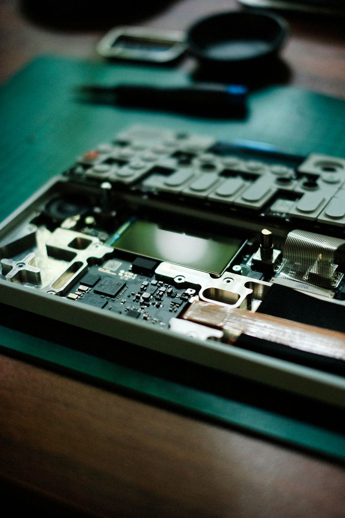An opened hard disk drive on a workbench during a data recovery job